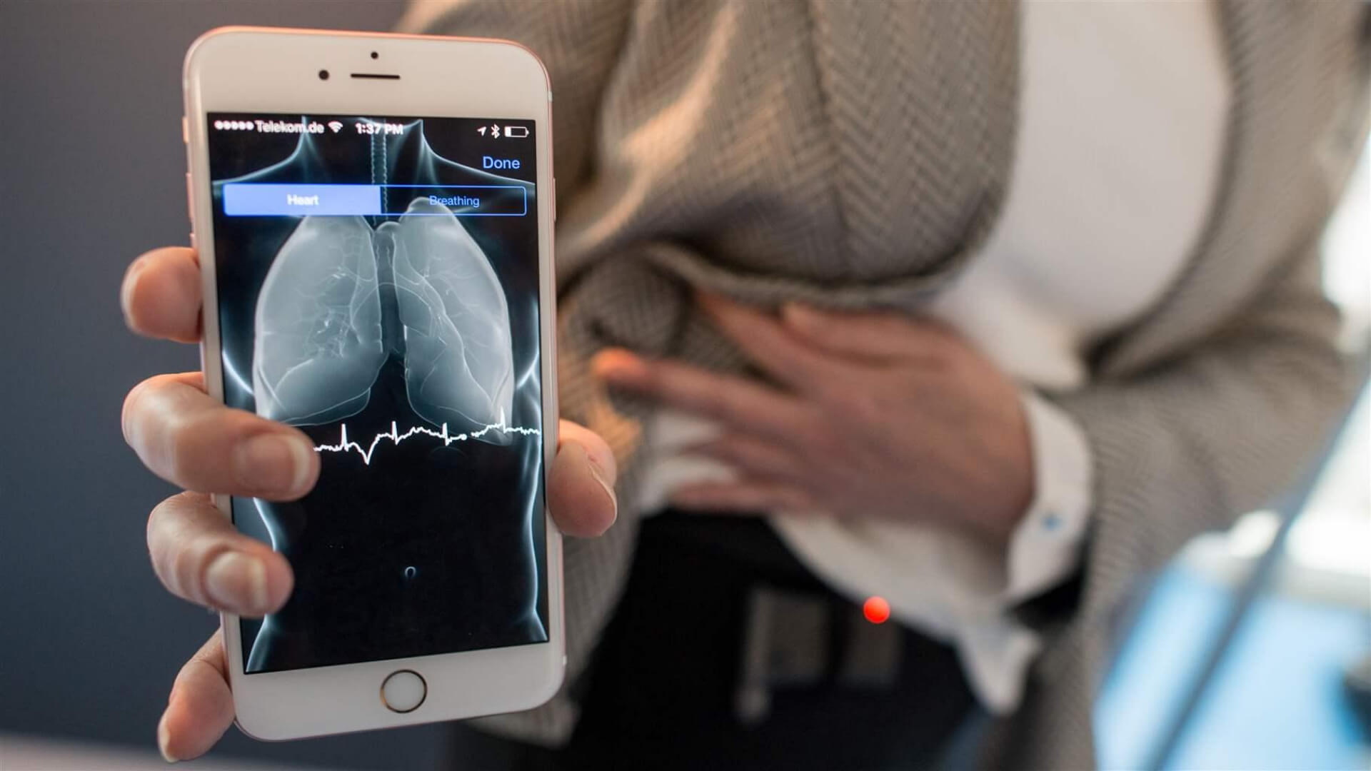 a woman holding up a smartphone with an image of a ct scan