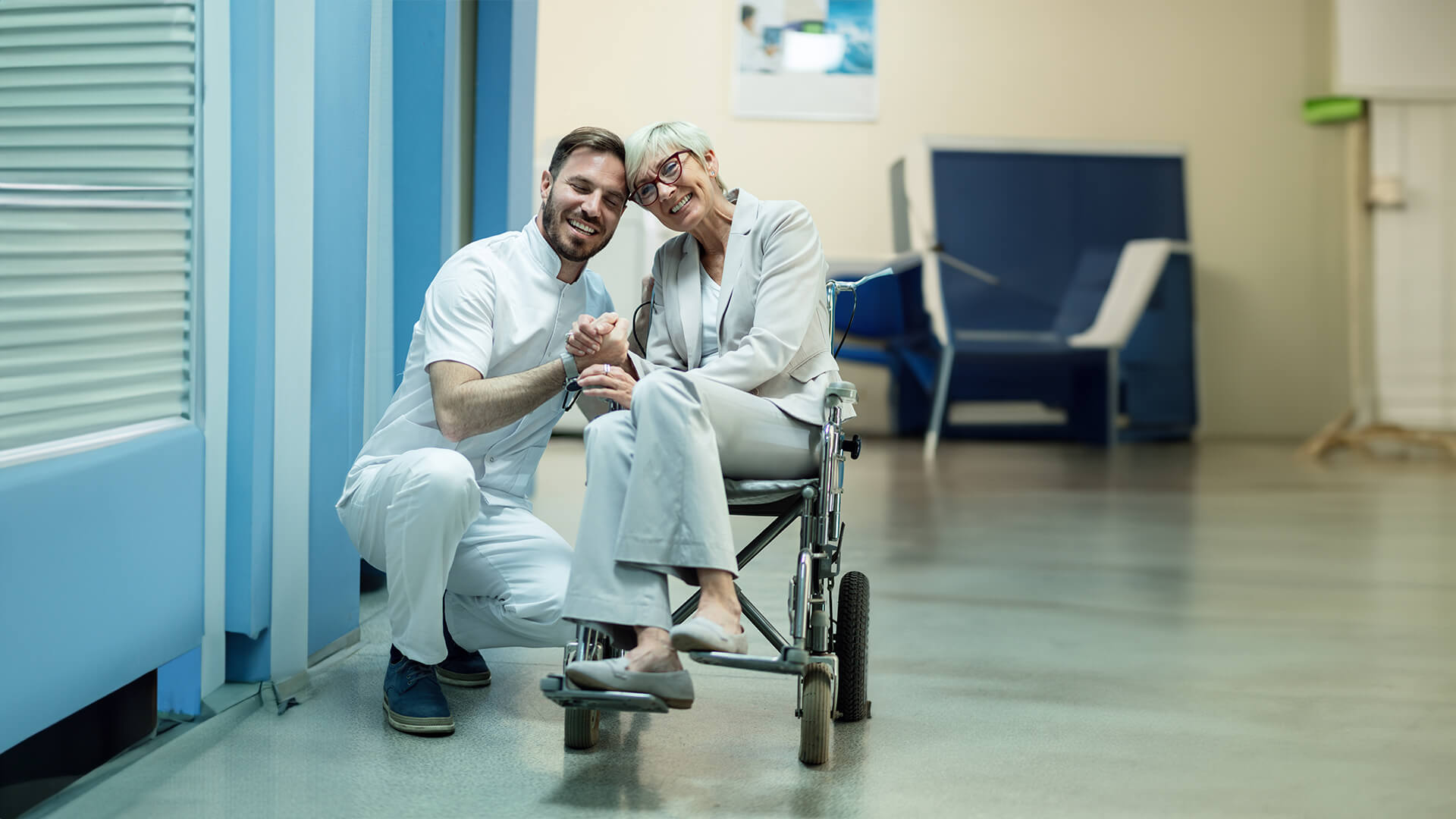 a female patient in wheelchair navigate a hospital corridor, assisted by a medical staff