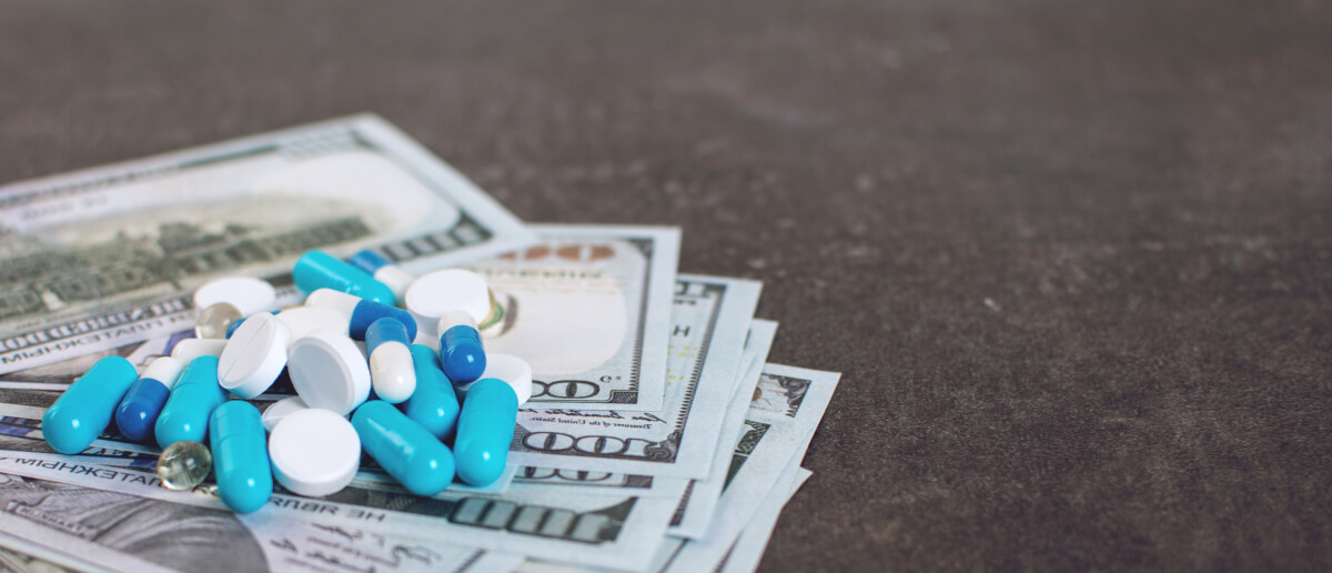 a pile of pills on top of a stack of dollars