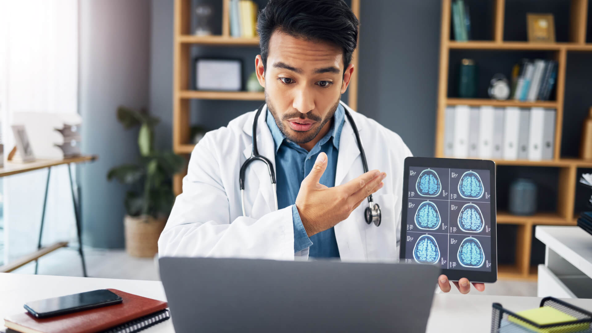 a doctor looking at a laptop explaining an mri image