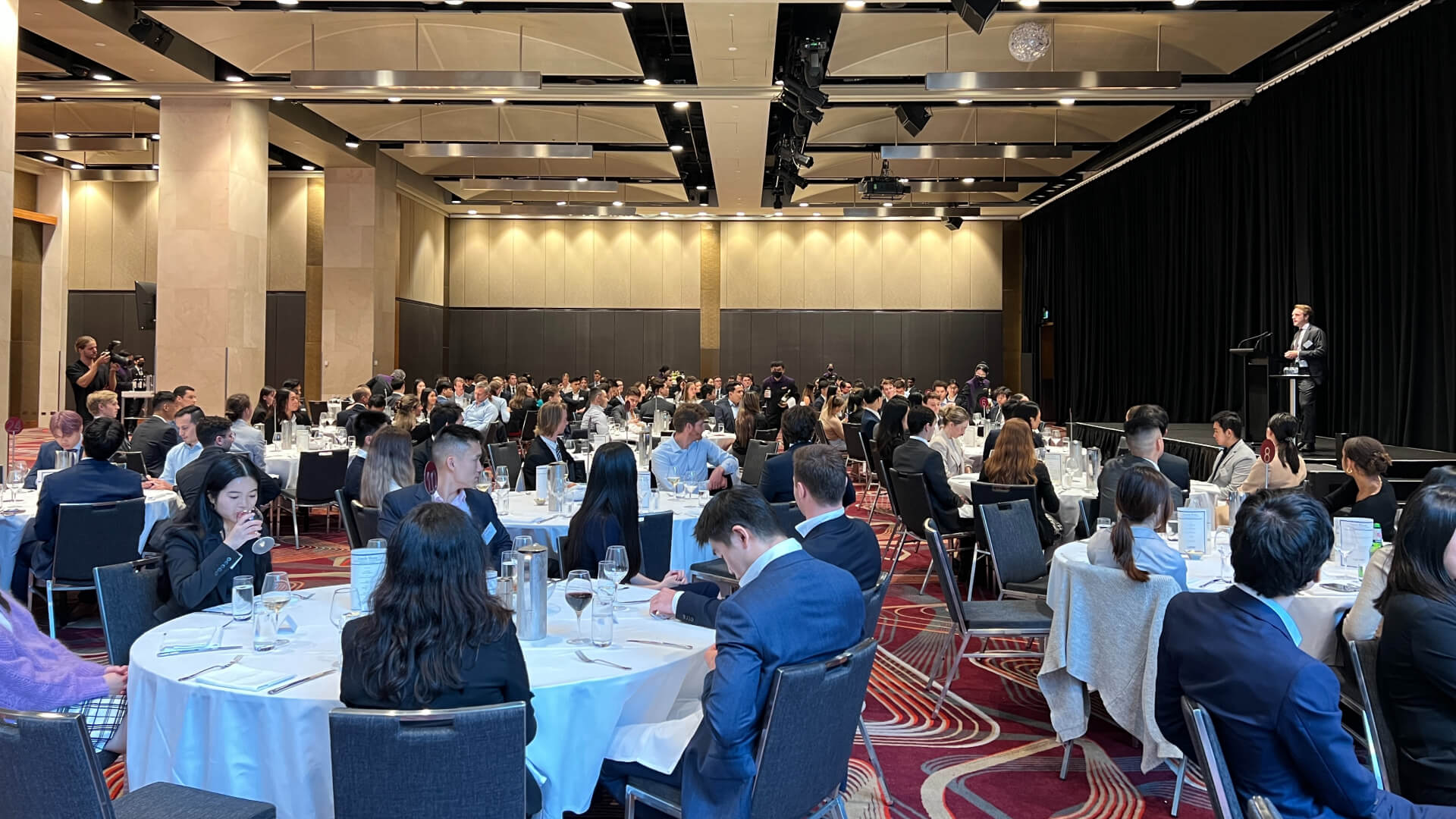 a large group of people sitting at tables in a large room