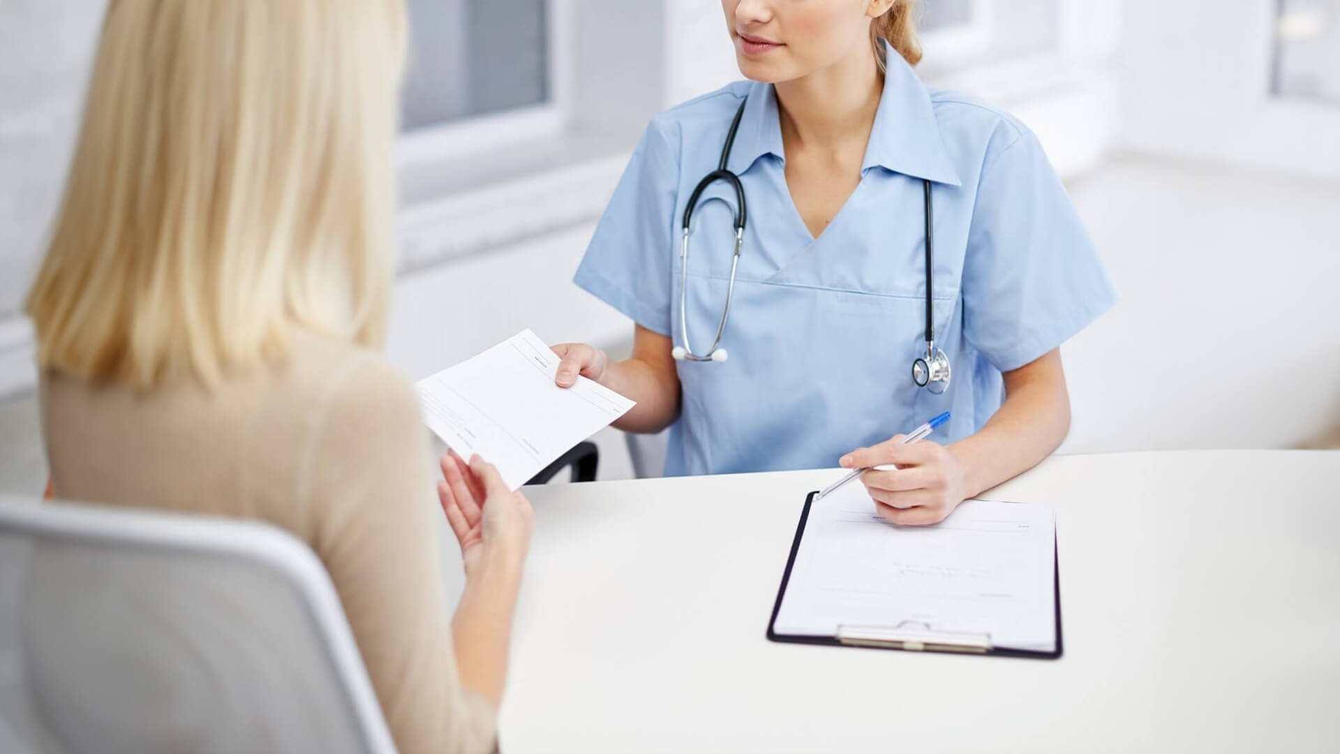 a nurse is talking to a patient at a desk