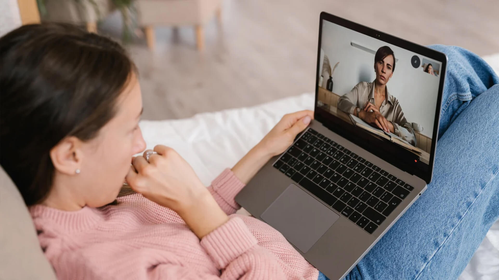 a woman sitting on a bed with a laptop on her lap