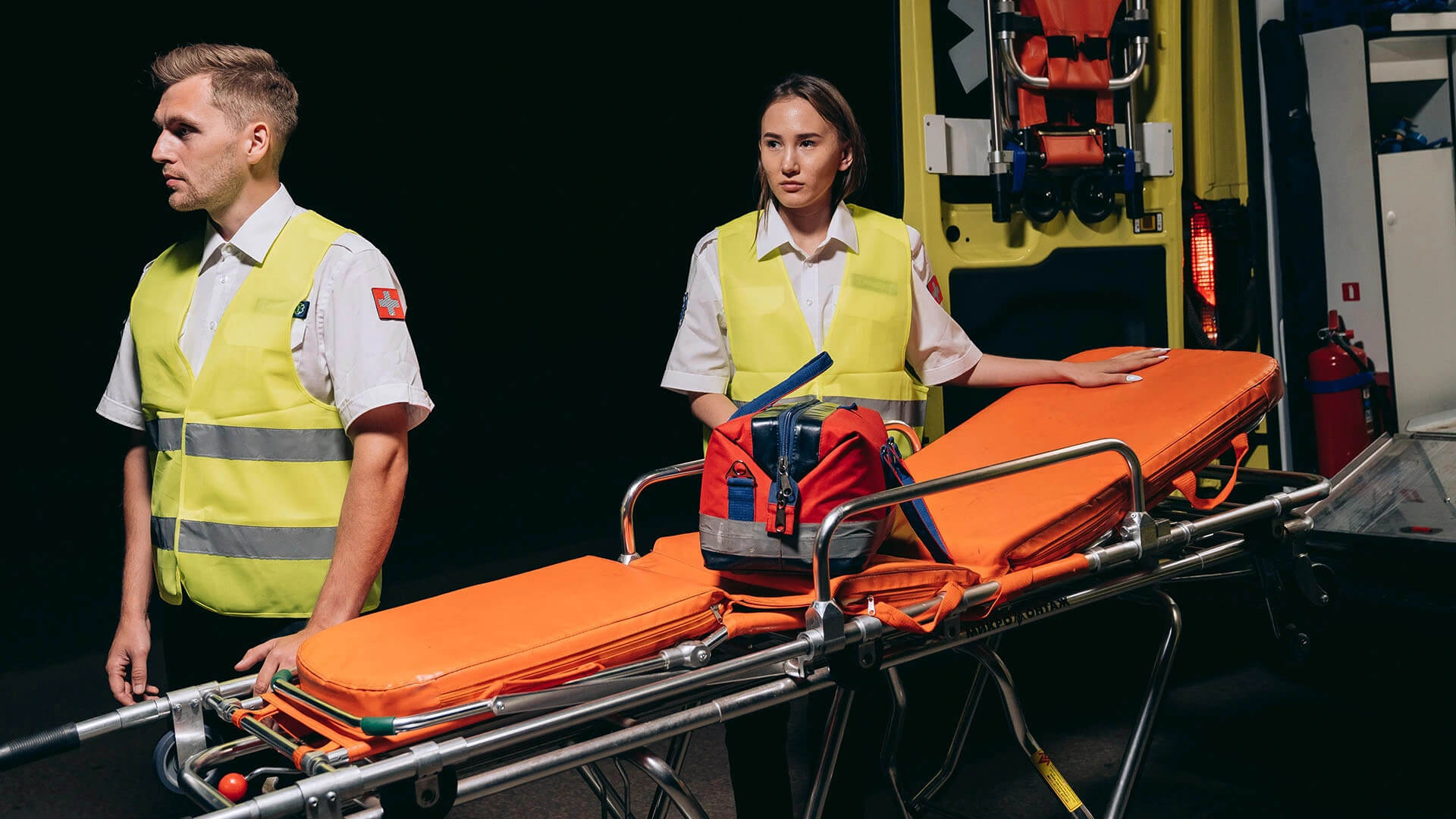 two emergency workers standing next to a stretcher