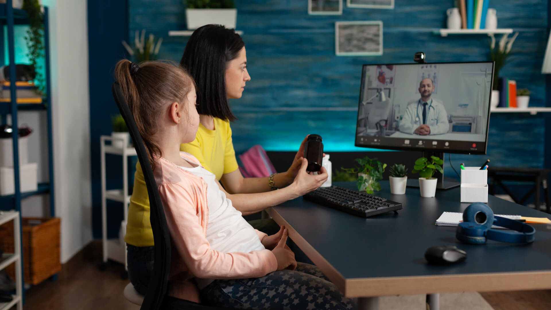 a woman and a child are doing a video consultation with a doctor on a computer