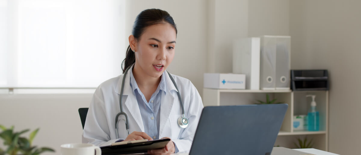 a female doctor using a laptop in her office