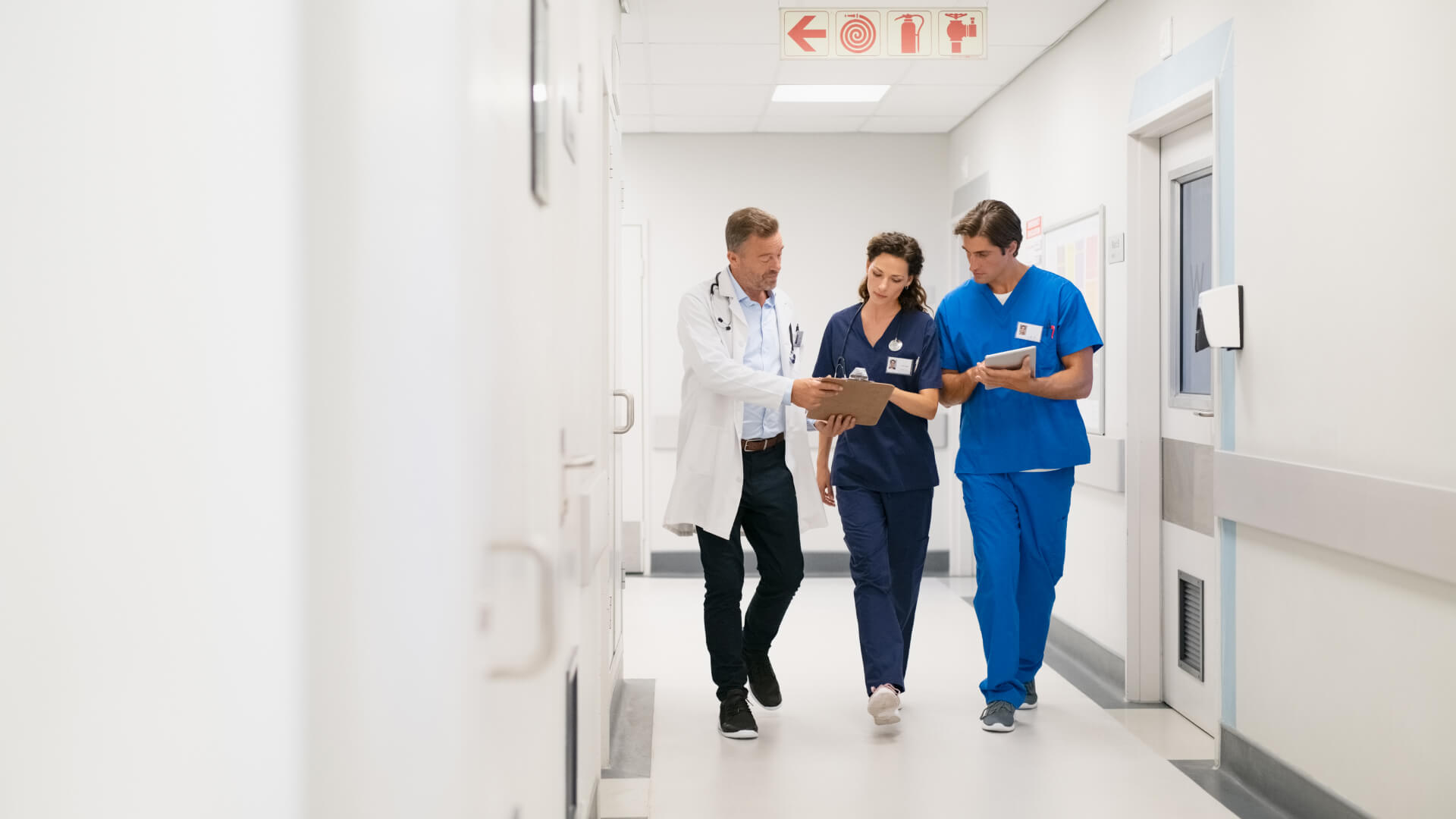 a group of doctors and nurses walking down a hallway